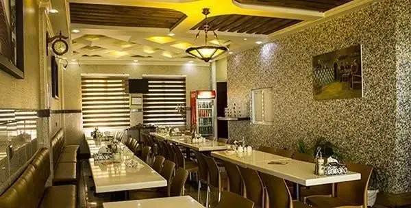 فضای داخلی رستوران طباخی کاج سعادت آباد با میز و صندلی‌های چیده شده، نورپردازی مدرن و دکوراسیون گرم و دلنشین آماده پذیرایی از مشتریان.