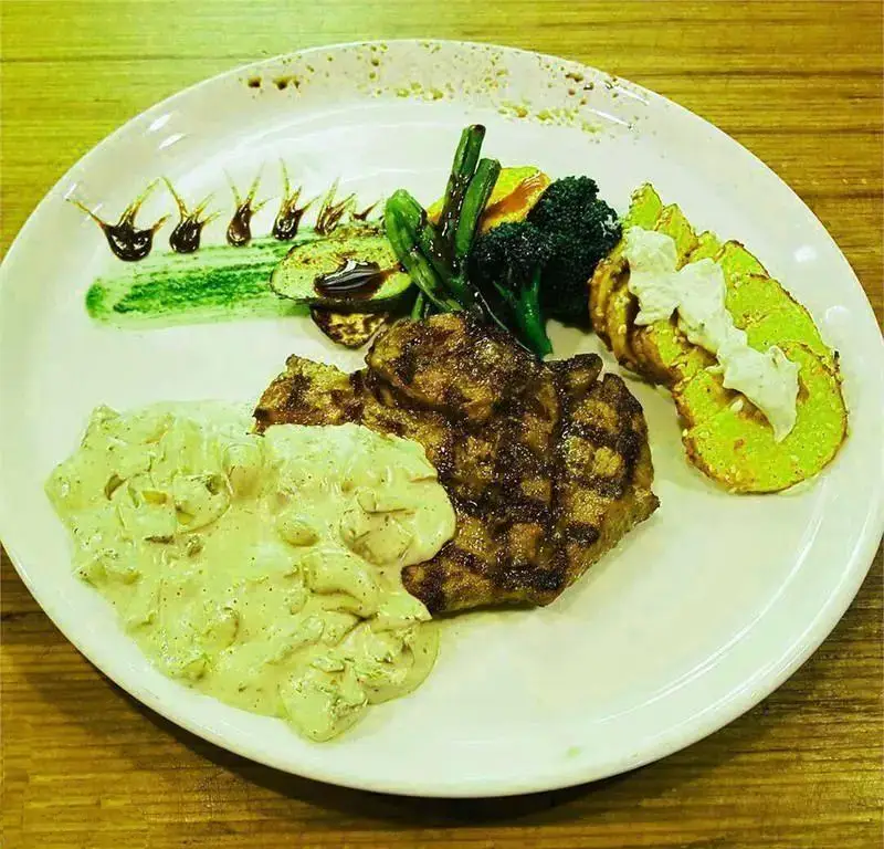 یک بشقاب غذای اصلی لذیذ شامل استیک گریل حرفه‌ای با سس قارچ خامه‌ای، سبزیجات متنوع گریل و سیب‌زمینی مخصوص جاسنتو