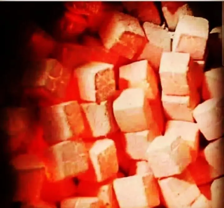 تصویری از زغال‌های گداخته و آماده برای سرو قلیان در کافه و سفره خانه سنتی دلکده، نشان‌دهنده فضایی گرم و دلنشین.