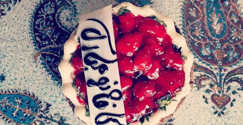 کیک توت فرنگی ویژه و خوش طعم کافه دلکده با روکش سس میوه و تزئین خامه، بهترین دسر برای لحظات شیرین شما.