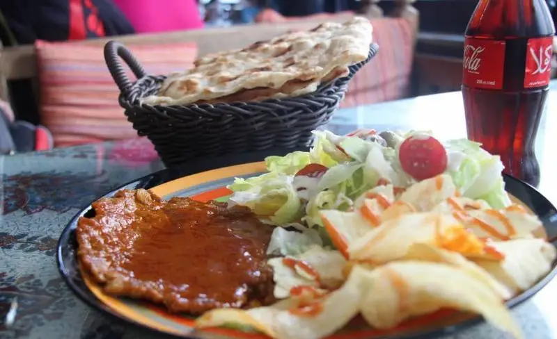 غذای خوشمزه در کافه و سفره خانه دلکده؛ خوراک گوشت با سس، سالاد تازه، نان سنتی داغ و نوشابه. تجربه‌ای دلنشین.