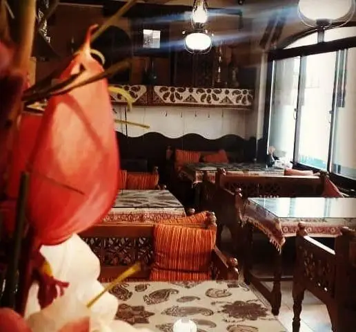 فضای گرم و دلنشین کافه و سفره خانه سنتی دلکده با دکوراسیون اصیل ایرانی و مبلمان چوبی منبت‌کاری شده.