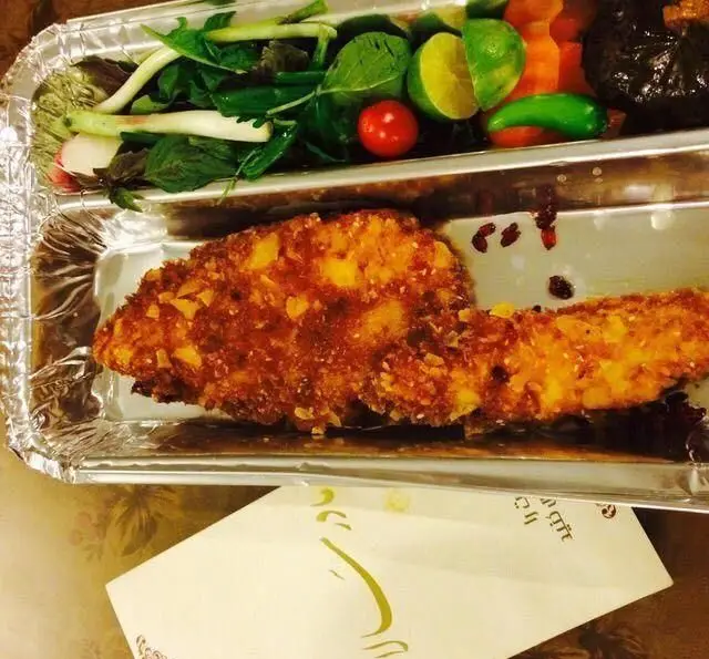 غذای خانگی مادرانه مادر سالار: سینی غذای بیرون‌بر حاوی تکه‌های مرغ سوخاری یا ماهی ترد، به همراه سالاد سبزیجات تازه، گوجه فرنگی، پیازچه و لیمو.