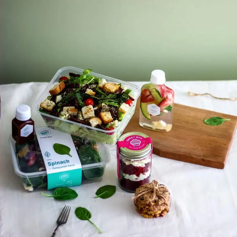 فرش باکس: سفارش غذای رژیمی سالم شامل سالاد اسفناج، آبمیوه دتاکس، دسر و کوکی، آماده برای تحویل و سرو.