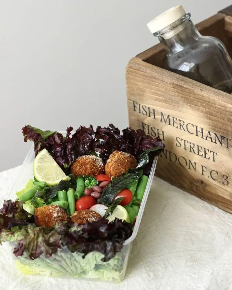 سالاد رژیمی و تازه فرش باکس با کاهو، سبزیجات متنوع، گوجه، لیمو و لقمه‌های کریسپی، غذایی سالم برای ناهار یا شام.