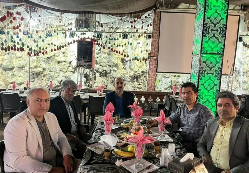 تصویری از شش مهمان مرد در حال صرف غذا در رستوران هودین، با میز آرایی زیبا و فضای داخلی دکوراتیو چشم‌نواز.