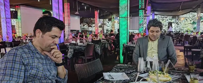 مشتریان در رستوران هودین، در فضایی زیبا با ستون‌های نورانی و دکوراسیون خاص، از غذای لذیذ و محیطی دلنشین لذت می‌برند.