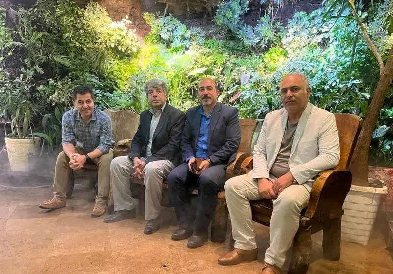 چهار مرد در حال گفتگو و دورهمی در فضای سبز و دلنشین رستوران هودین، با دکوراسیون خاص و محیطی ایده‌آل برای شما.