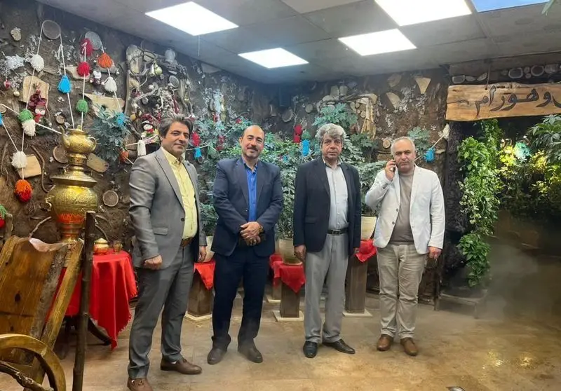 چهار مرد در فضای داخلی دلنشین و سنتی رستوران هودین با دکوراسیون جذاب، از جمله سماور و تزئینات محلی، حضور دارند.