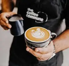 در کافه دلفین، باریستا حرفه‌ای با مهارت لاته آرت زیبا را در فنجانی شیک سرو می‌کند، نشانه‌ای از کیفیت و تجربه دلنشین قهوه.