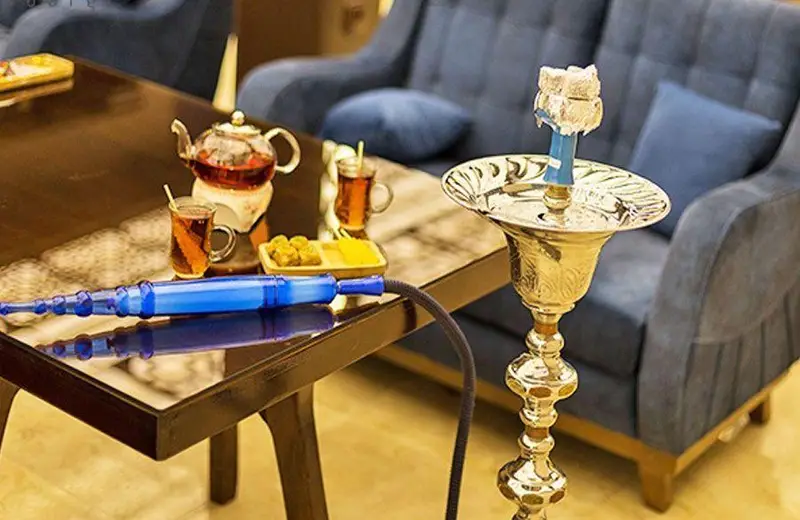 فضای دلنشین کافه دلفین با میز قلیان سنتی، چای تازه دم و شیرینی؛ مکانی عالی برای دورهمی و آرامش در کافه