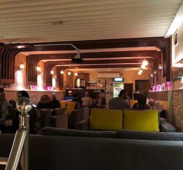 فضای داخلی سفره خانه رز سیاه با مشتریان بر روی مبلمان راحت، نورپردازی دلنشین و دکوراسیون جذاب. محیطی آرام و دنج.