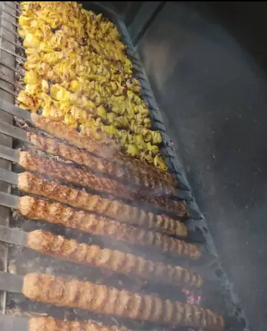 کباب‌های خوشمزه و داغ جوجه و کوبیده در منقل ذغالی رستوران مستر باربیکیو در حال پخت است. لذت غذای ایرانی با کباب تازه.