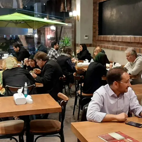 مشتریان در حال لذت بردن از فضای صمیمی و دلنشین رستوران مستر باربیکیو، مکانی عالی برای دورهمی و تجربه طعم‌های بی‌نظیر.