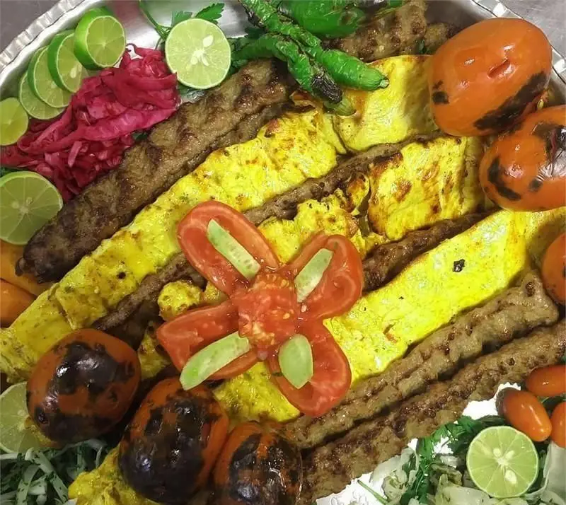 سینی شاهانه کباب کوبیده و جوجه به همراه گوجه کبابی، فلفل، لیمو و مخلفات تازه در رستوران ایرانی کاه گل.