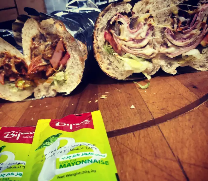 ساندویچ‌های پرملات و خوشمزه بمب آرش با پنیر کشی، کالباس، ژامبون، سبزیجات تازه و سس مایونز بیژن. تجربه‌ای لذیذ و به یادماندنی از بمب‌های آرش.