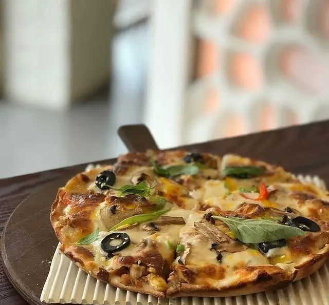 پیتزا قارچ و زیتون سیاه خوشمزه از فست فود چهل سی، با پنیر فراوان و سبزیجات تازه. بهترین انتخاب برای یک وعده غذایی دلپذیر.