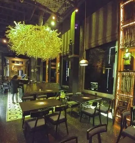 رستوران آسیایی ماساکی: فضای داخلی مدرن با لوستر برگ‌مانند زرد، میز و صندلی‌های راحت و دکوراسیون منحصر به فرد برای تجربه غذای آسیایی.