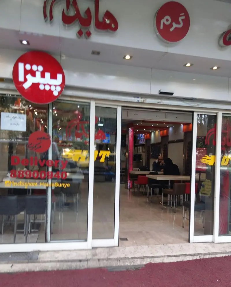 نمای کامل رستوران فست فود ساندویچ هایدا، ارائه دهنده پیتزا و غذاهای گرم، همراه با تابلوی دلیوری و شماره 88900940 و ورودی.