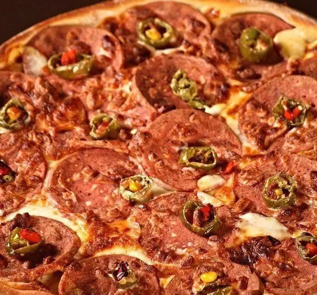 پیتزا پپرونی داغ با فلفل سبز تند و پنیر کش‌دار، از غذاهای محبوب و پرطرفدار کافه رستوران گردو.