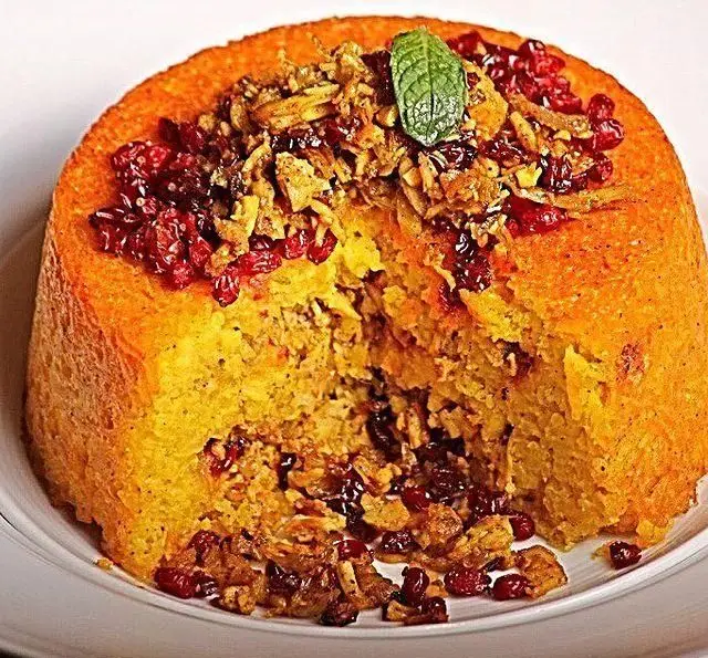 ته چین زعفرانی مجلسی و طلایی رنگ با مغز برنج، مرغ، زرشک، خلال و پیاز داغ، سرو شده در کافه رستوران گردو.