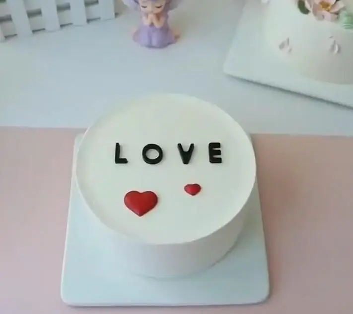 زیباترین کیک سفید LOVE از قنادی سهند با قلب‌های قرمز کوچک و بزرگ، انتخابی شیرین برای ابراز عشق و ولنتاین.
