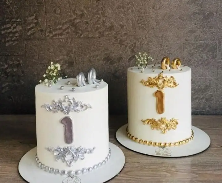 کیک تولد یک سالگی قنادی سهند با دکوراسیون شیک طلایی و نقره‌ای. دو مدل کیک لاکچری مناسب جشن‌ها و مراسم ویژه یک سالگی.