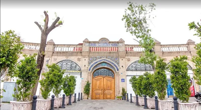 تصویر نمای بیرونی کافه رستوران وکیل التجار، دارای معماری سنتی ایرانی، کاشی‌کاری آبی رنگ و ورودی چوبی باشکوه.