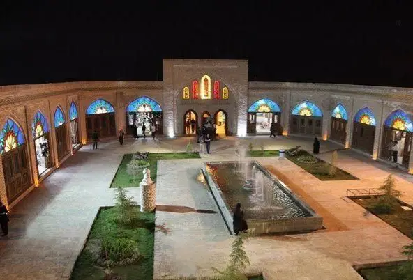 نمای شب کافه رستوران وکیل التجار یزد؛ حیاط سنتی با معماری اصیل، آبنما، نورپردازی دلنشین و فضای باز ایده‌آل برای شب‌نشینی‌ها و صرف غذا.