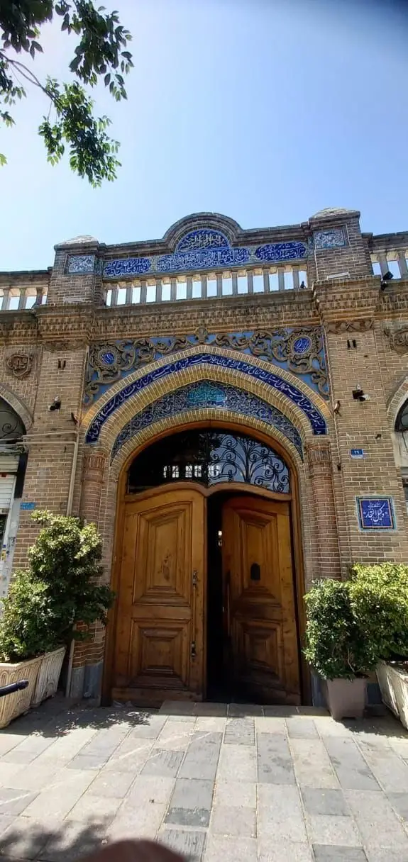 ورودی چشم‌نواز کافه رستوران وکیل التجار، نمادی از معماری اصیل ایرانی با کاشی‌کاری‌های آبی، خطاطی و درهای چوبی.