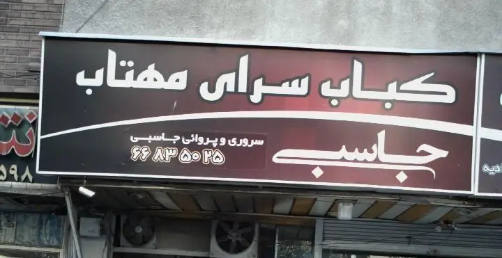 تابلوی کباب سرای مهتاب جاسبی، رستورانی محبوب برای انواع کباب ایرانی. شامل نوشته‌های سفید برجسته و شماره تماس، آماده پذیرایی.