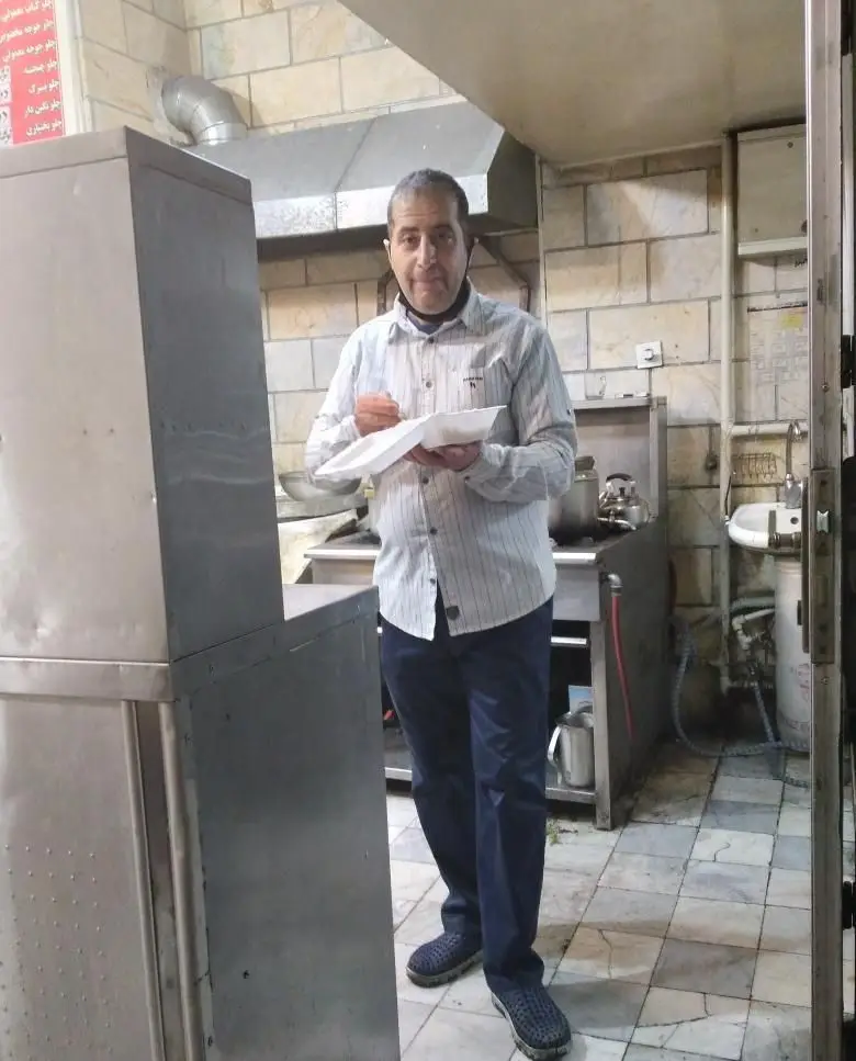 یک پرسنل مجرب کباب سرای مهتاب جاسبی در حال سرو یا تست غذا، تضمین‌کننده طعم اصیل و کیفیت برتر کباب‌ها در آشپزخانه‌ای بهداشتی.