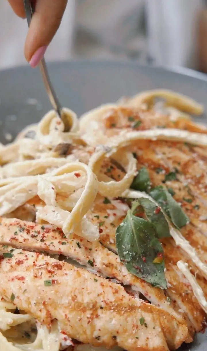 یک وعده لذیذ پاستا فتوچینی با سس خامه ای، فیله مرغ گریل شده و ادویه های خوش طعم در کافه رستوران ایتالیایی سنسو.