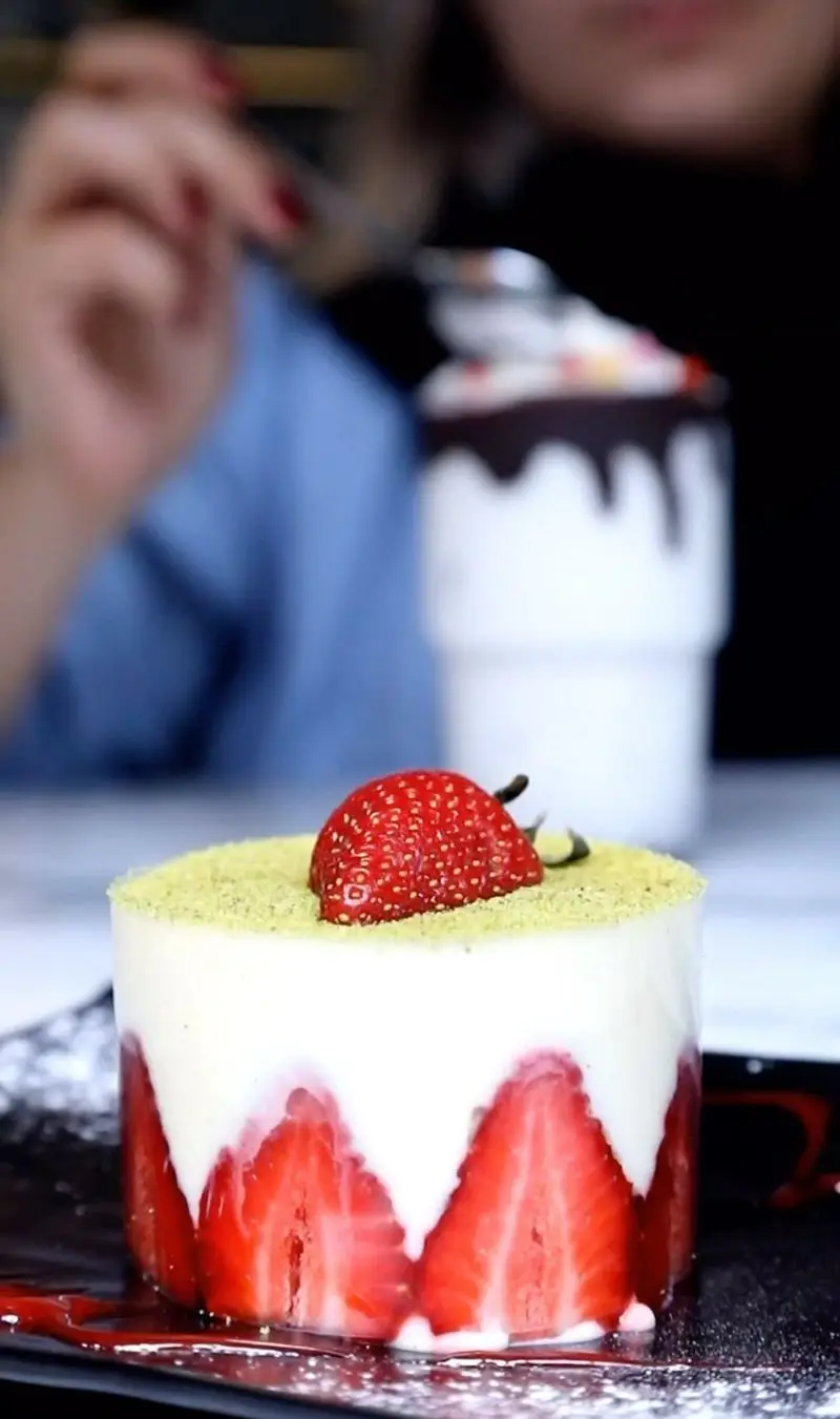 دسر توت فرنگی خوشمزه و زیبای کافه سنسو، با لایه‌های خامه و توت‌فرنگی تازه و پودر پسته. تجربه‌ای شیرین در رستوران ایتالیایی سنسو.