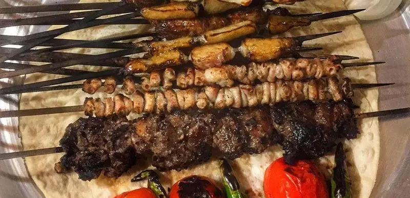 انواع کباب‌های ایرانی خوشمزه جگرکی پاجین شامل جگر، جوجه، دل و قلوه و کوبیده همراه با گوجه و فلفل کبابی روی نان تازه