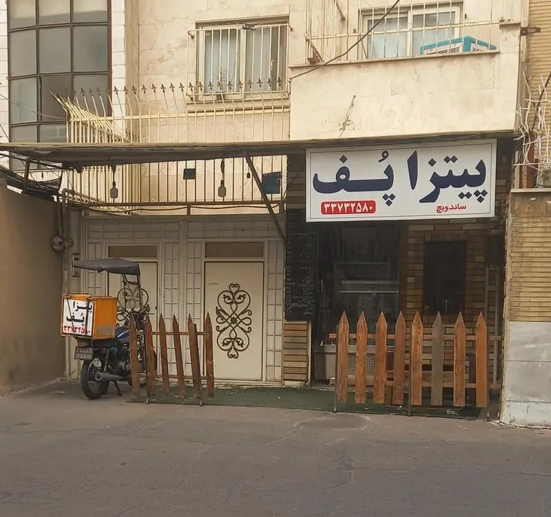 نمای بیرونی جذاب فست فود پیتزا پف که انواع پیتزا و ساندویچ ارائه می‌دهد، با تابلوی شماره تماس و موتور آماده تحویل غذا.