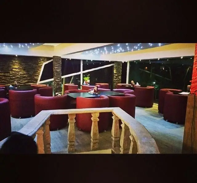 محیط شیک و زیبای فست فود دیاکو در شب، شامل صندلی‌های قرمز، میزهای بزرگ و نورپردازی سقفی، ایده‌آل برای یک وعده عالی.