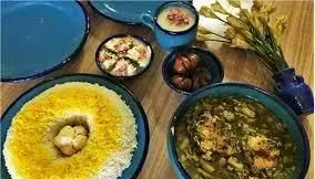 سفره غذای سنتی و لذیذ گیلان خوراک تالش با خورش محلی گیلانی، برنج زعفرانی و مخلفات شمالی در ظروف آبی. رستوران.