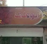تصویر تابلوی بزرگ و جذاب کسب و کار ساندویچی فلافل ابوعلی، با پس‌زمینه گرم و نام "ابوعلی" در مرکز آن، بالای درب ورودی فروشگاه غذا.