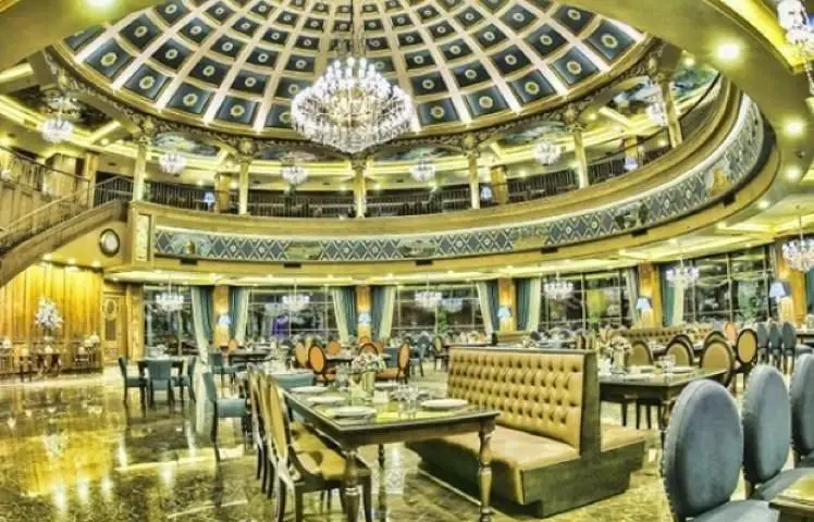 نمایی از فضای داخلی مجلل کافه و رستوران کاخ لیدوما با سقف گنبدی، لوسترهای بزرگ، مبلمان راحت و دکوراسیون طلایی و آبی.