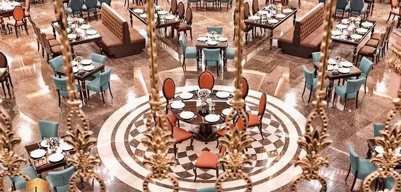 تصویری زیبا از فضای داخلی باشکوه و مجلل کافی شاپ کاخ لیدوما با چیدمان متنوع میز و صندلی‌های شیک و آماده پذیرایی از مهمانان.