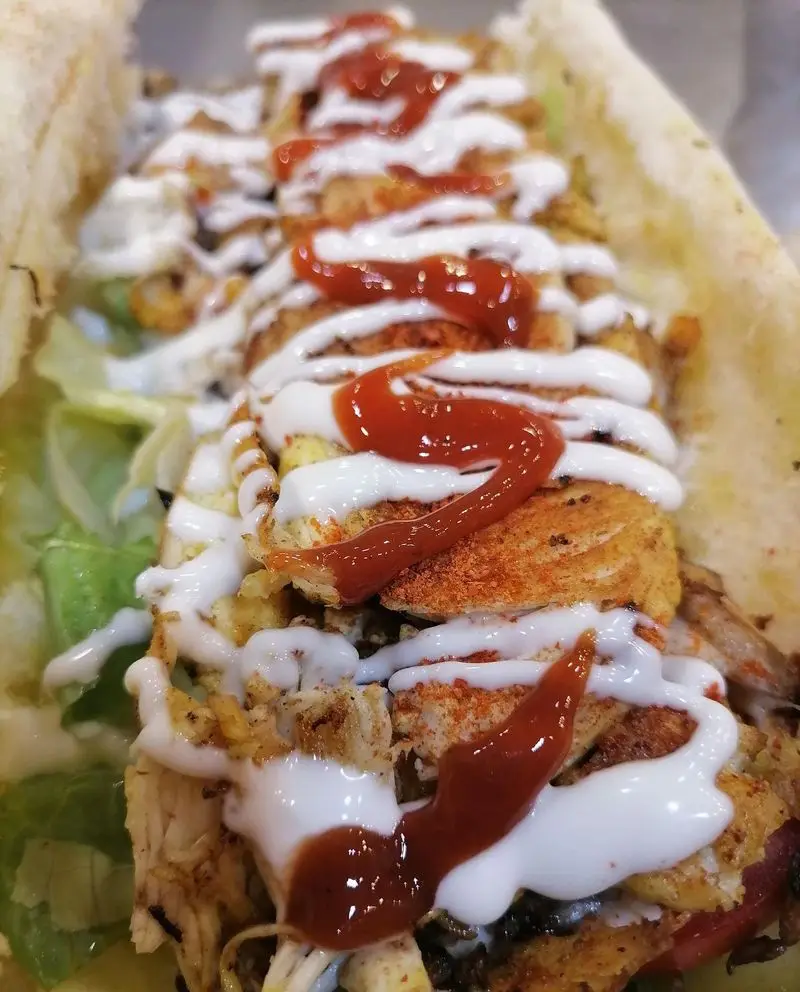 ساندویچ هایلا: نمای نزدیک از ساندویچ لذیذ مرغ و تخم‌مرغ با چاشنی‌های مخصوص، کاهو، سس مایونز و کچاپ فراوان در نان تازه.
