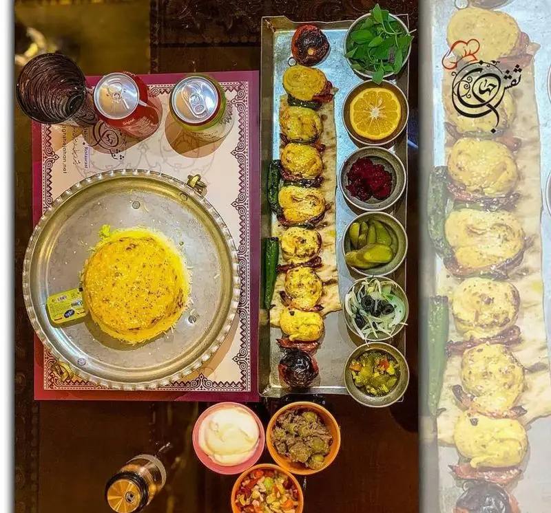 سفره‌ای شاهانه از غذاهای ایرانی در کاخ رستوران نقش جهان: جوجه کباب، ته چین زعفرانی، مخلفات متنوع و نوشیدنی‌های خنک.