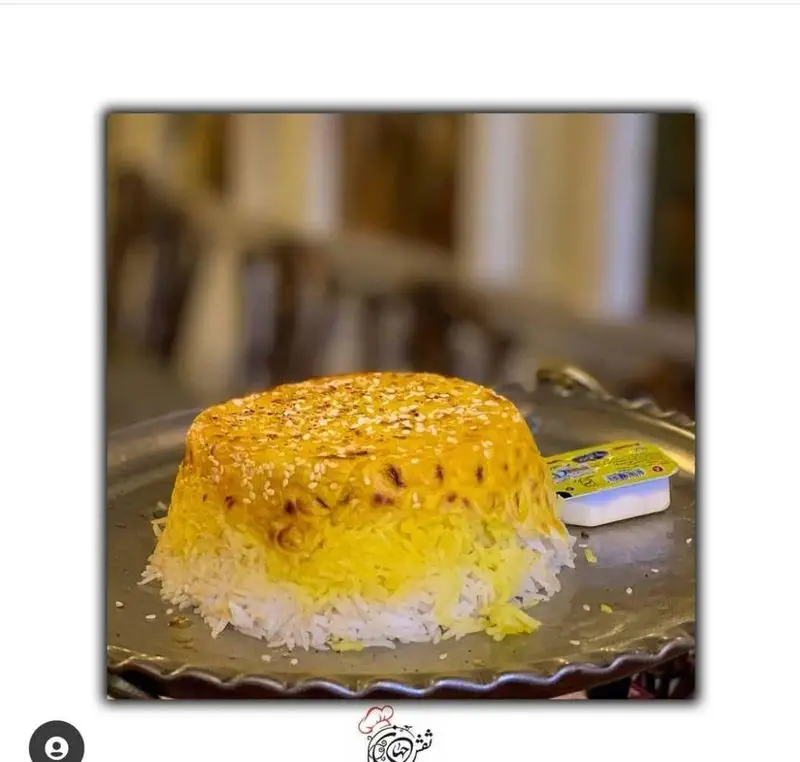 تصویری جذاب از ته‌چین زعفرانی مجلسی کاخ رستوران نقش جهان، با برنج خوش‌عطر و ته‌دیگ طلایی کنجدی، انتخابی بی‌نظیر برای تجربه غذای اصیل ایرانی.