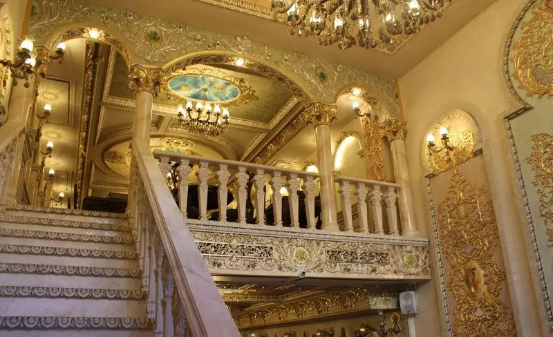 دکوراسیون داخلی مجلل کاخ رستوران نقش جهان با راه‌پله مرمر، تزیینات طلایی، بالکن و سقف نقاشی شده باشکوه.