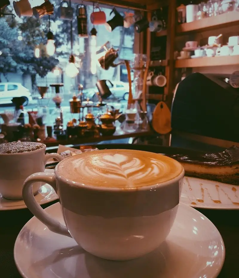 لذت نوشیدن لاته آرت زیبا و قهوه داغ در کافه ایستگاه (لاله). فضایی دلنشین با دکوراسیون خاص، ایده‌آل برای استراحت و ملاقات.