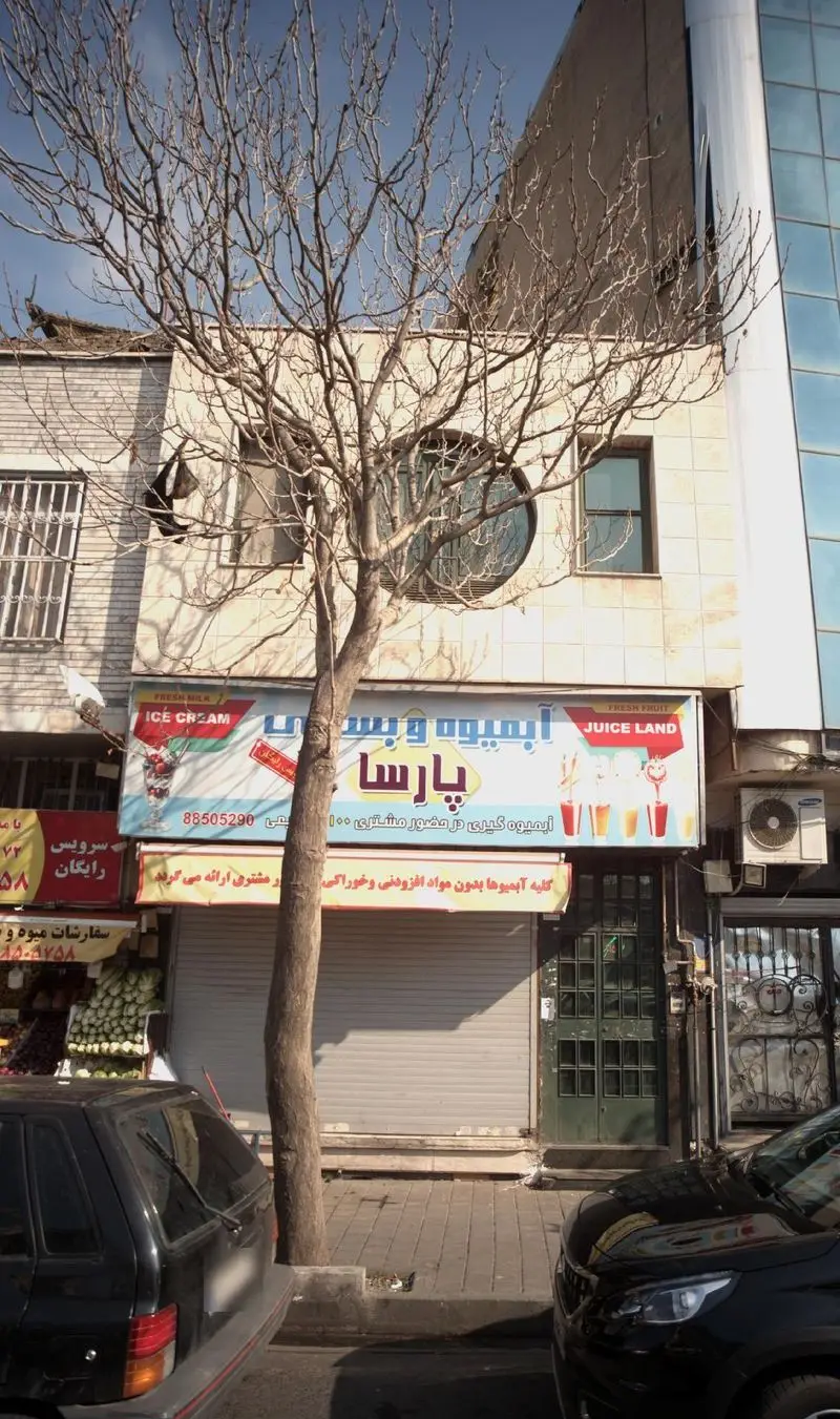 آبمیوه و بستنی پارسا: نمای بیرونی فروشگاه آبمیوه و بستنی با تابلوهای Fresh Milk, ICE CREAM و JUICE LAND در کنار خیابان.