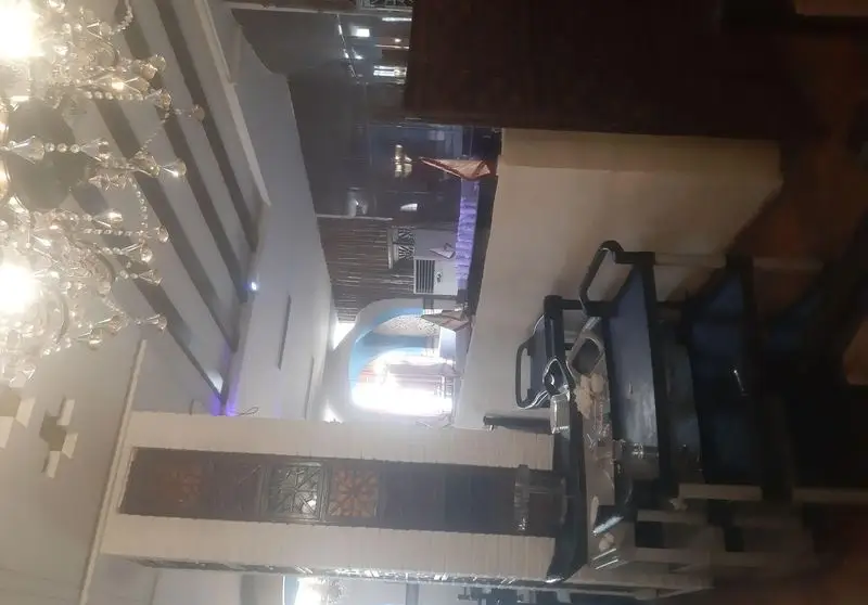 نمایی از دکوراسیون داخلی شیک رستوران شهربانو، شامل لوستر کریستالی، سقف مدرن، پارتیشن چوبی و فضای غذاخوری با نورپردازی زیبا.