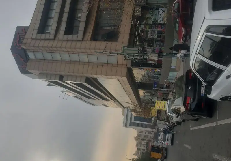 نمای خیابانی از رستوران شهربانو در شهر، نشان‌دهنده ورودی اصلی، تابلوی رستوران و محیط شهری با ترافیک و عابران پیاده.