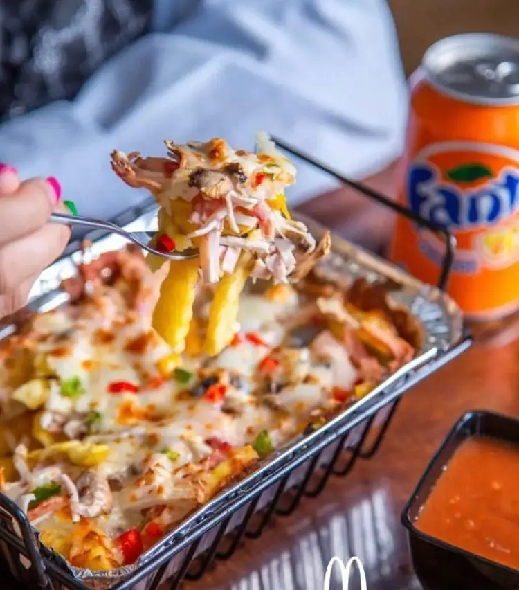 لذت طعم سیب زمینی پنیری پر ملات با مرغ و قارچ، سرو شده در فست فود مادر mother، همراه با نوشابه فانتا و سس.